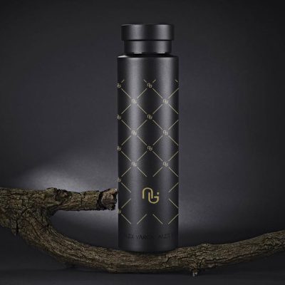 Moody image showing Luxury Large Vacuum Bottle in black with printed gold pattern and gold logo branding.